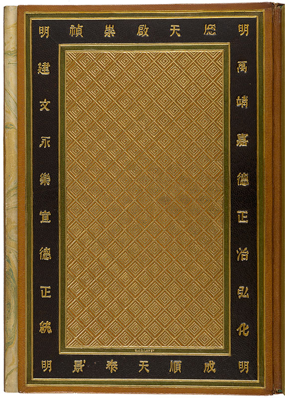 A closed book with a full leather design binding. Only the front cover is visible. The cover design is made up of different colored rectangular borders surrounding a large golden panel that has diamond designs in the center. The thickest surrounding border is black with gold tooled chinese letters. In the center below the gold panel there is the name the book binder imprinted into the leather using gold tooling. The name reads M.J.D. Lahey.